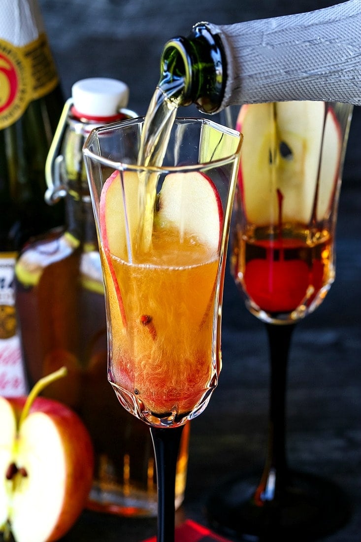 pouring sparkling cider into an apple cider cocktail
