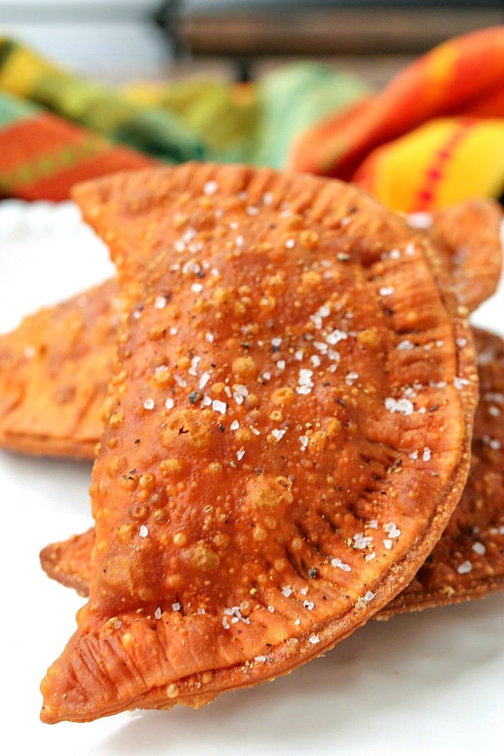 beef empanadas on a platter with salt