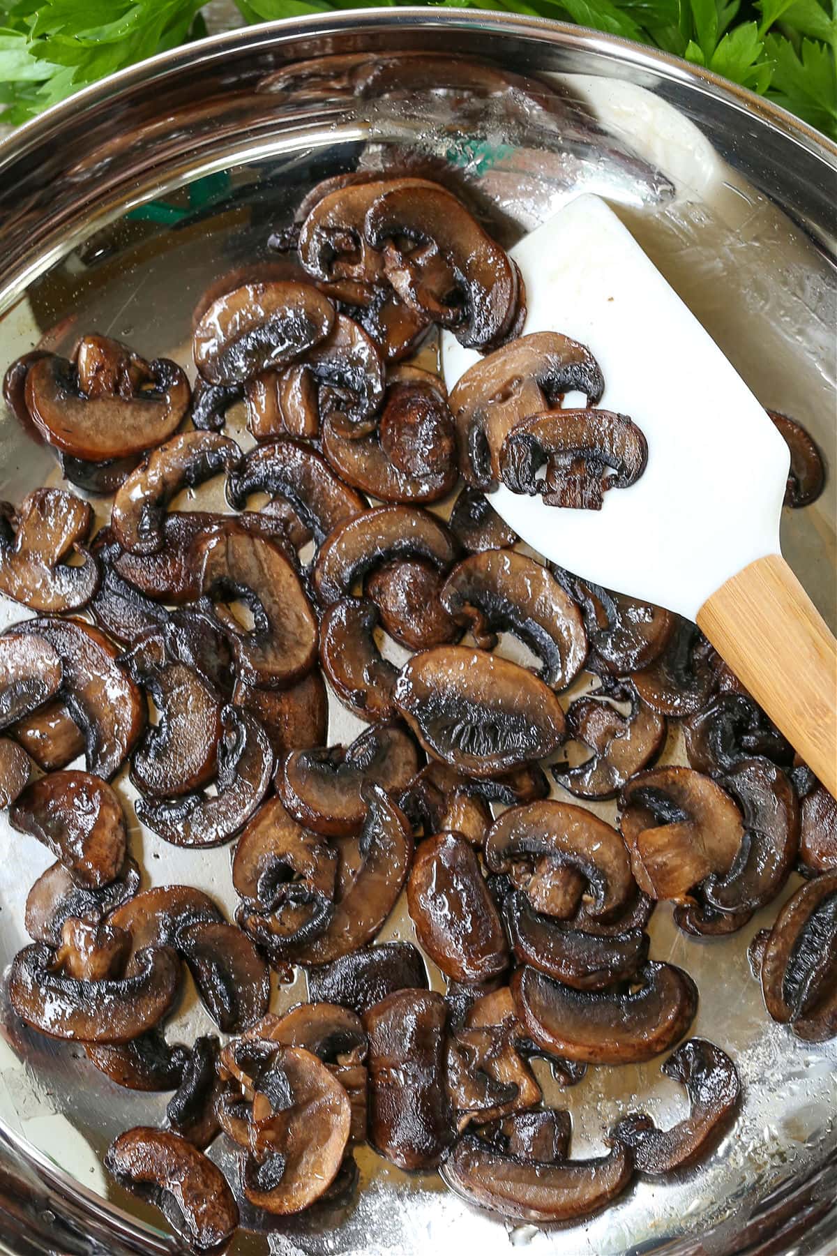browned mushrooms in a skillet with spatula