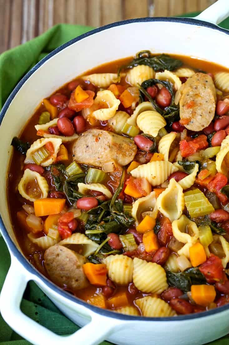 sausage minestrone soup in a white pot