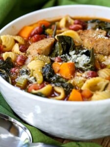 Sausage Minestrone Soup in a white bowl with parmesan cheese