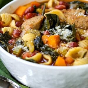 Sausage Minestrone Soup in a white bowl with parmesan cheese