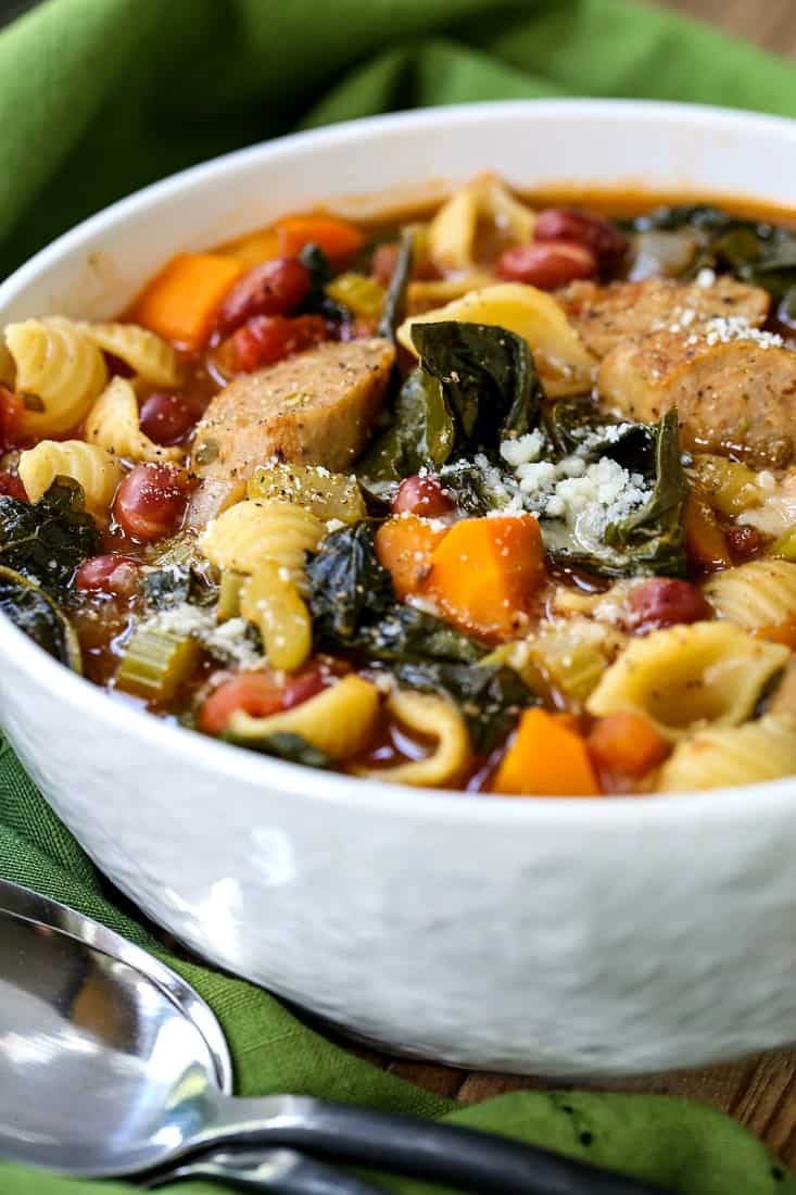 Sausage Minestrone Soup in a white bowl with parmesan cheese