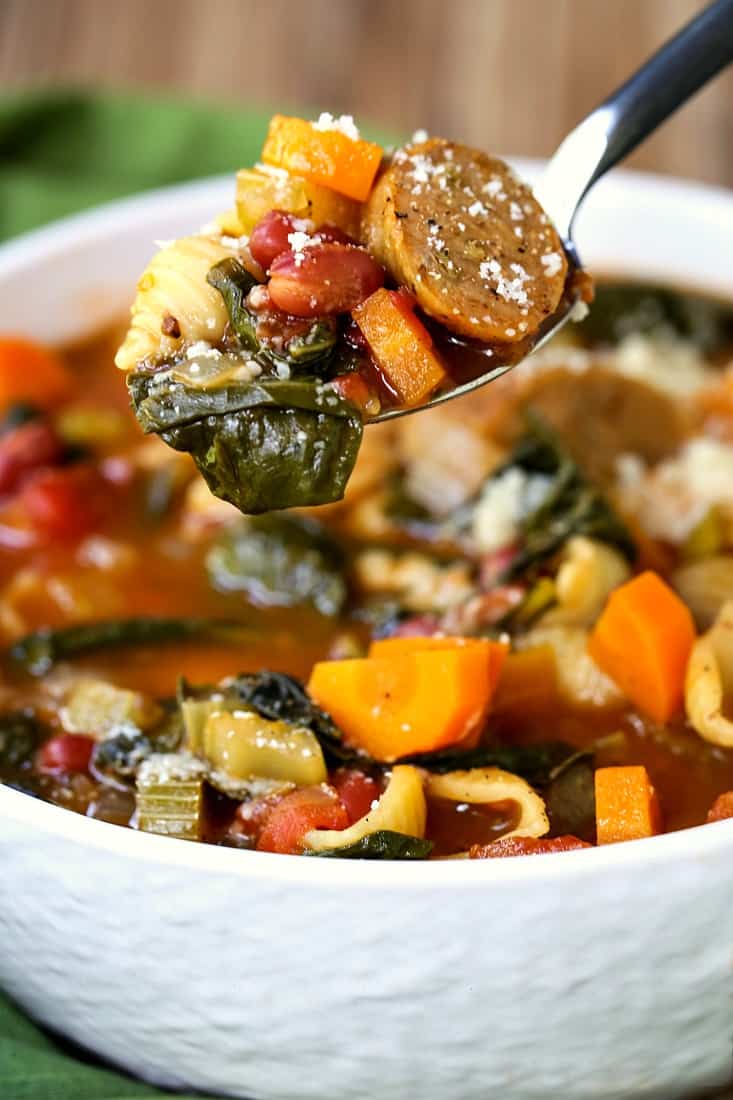 A spoon with sausage minestrone soup