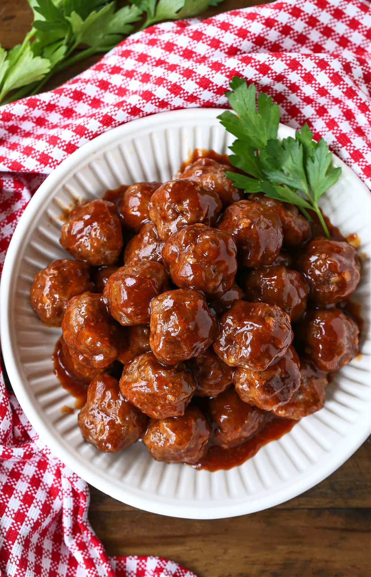 bbq meatballs in white bowl with checkered napkin