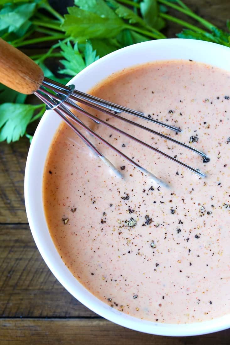 Remoulade sauce in a white bowl with whisk