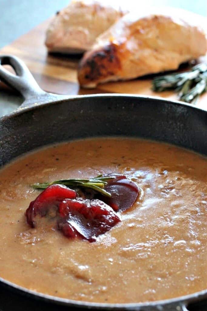 You're going to want to pour this Cranberry Turkey Gravy on everything! Cranberry sauce and bourbon add so much flavor than regular gravy! gravy in skillet with cranberry sauce