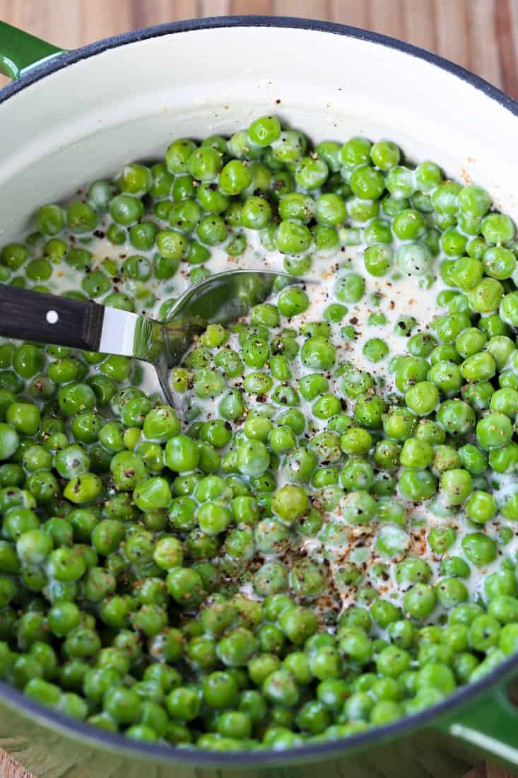 Creamed peas in a pot with a spoon