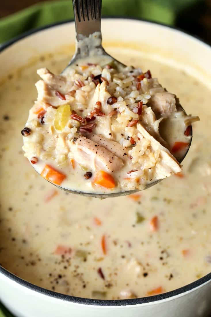 Creamy turkey soup with rice and vegetables on a ladle