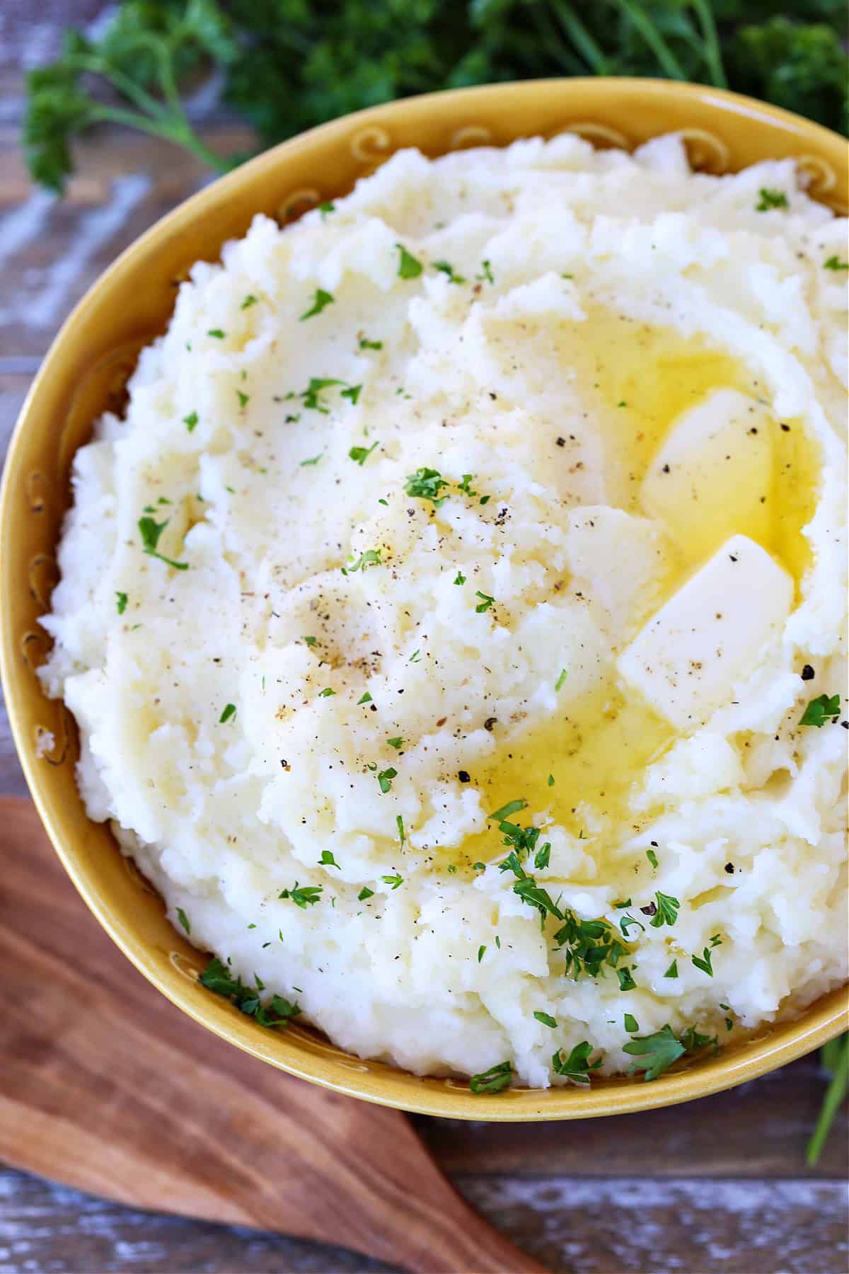 Our Fluffy Mashed Potatoes are so smooth and creamy, you won't make them any other way! A key tool makes these potatoes the best! mashed potatoes in bowl with butter and thyme