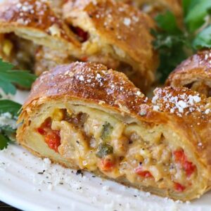 sausage and pepper strudel sliced on a white platter