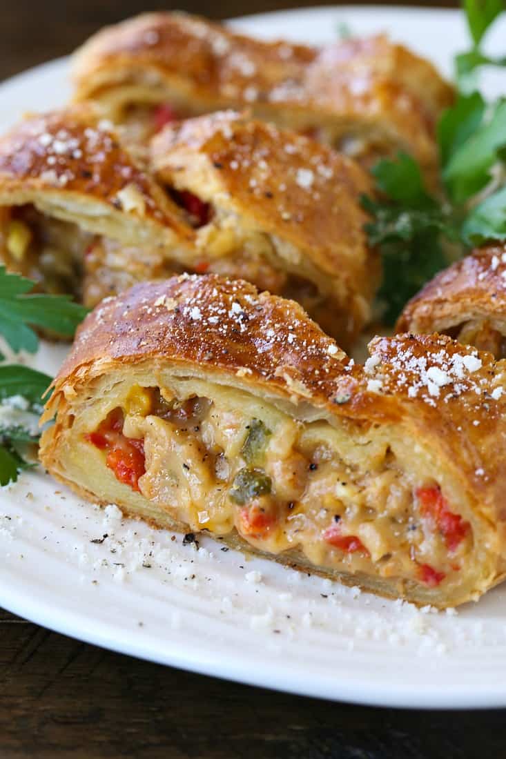 sausage and pepper strudel sliced on a white platter