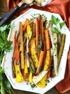 Roasted carrots with parsley on a white platter