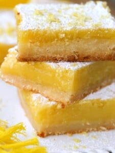 Lemon bars made with Limoncello stacked on white plate
