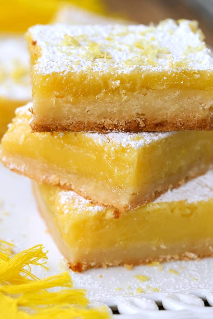 Lemon bars made with Limoncello stacked on white plate