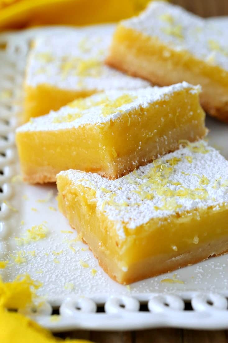 Lemon Bars stacked on platter with yellow napkin