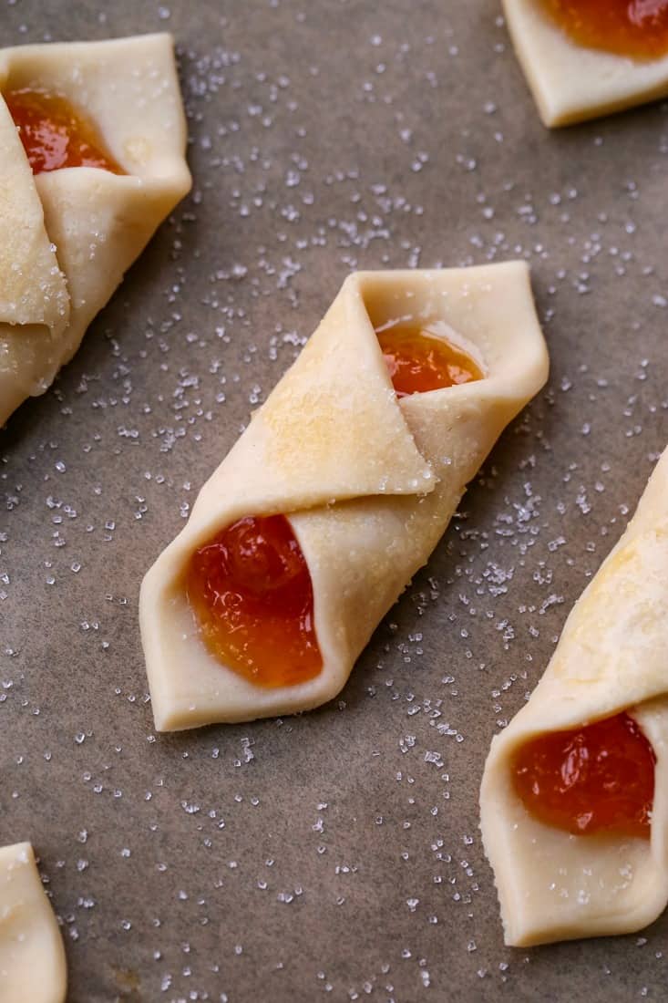 Polish cream cheese cookies on a baking sheet before going in the oven.