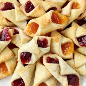 Jelly-filled Christmas cookies stacked on a platter.