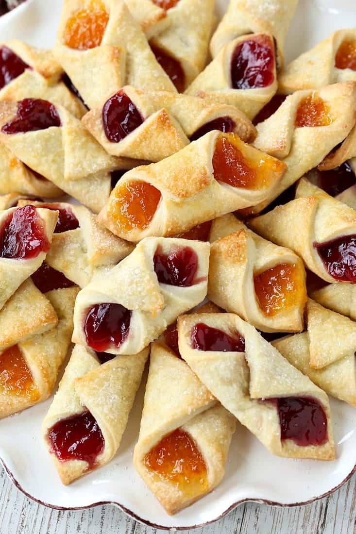 Jelly-filled Christmas cookies stacked on a platter.