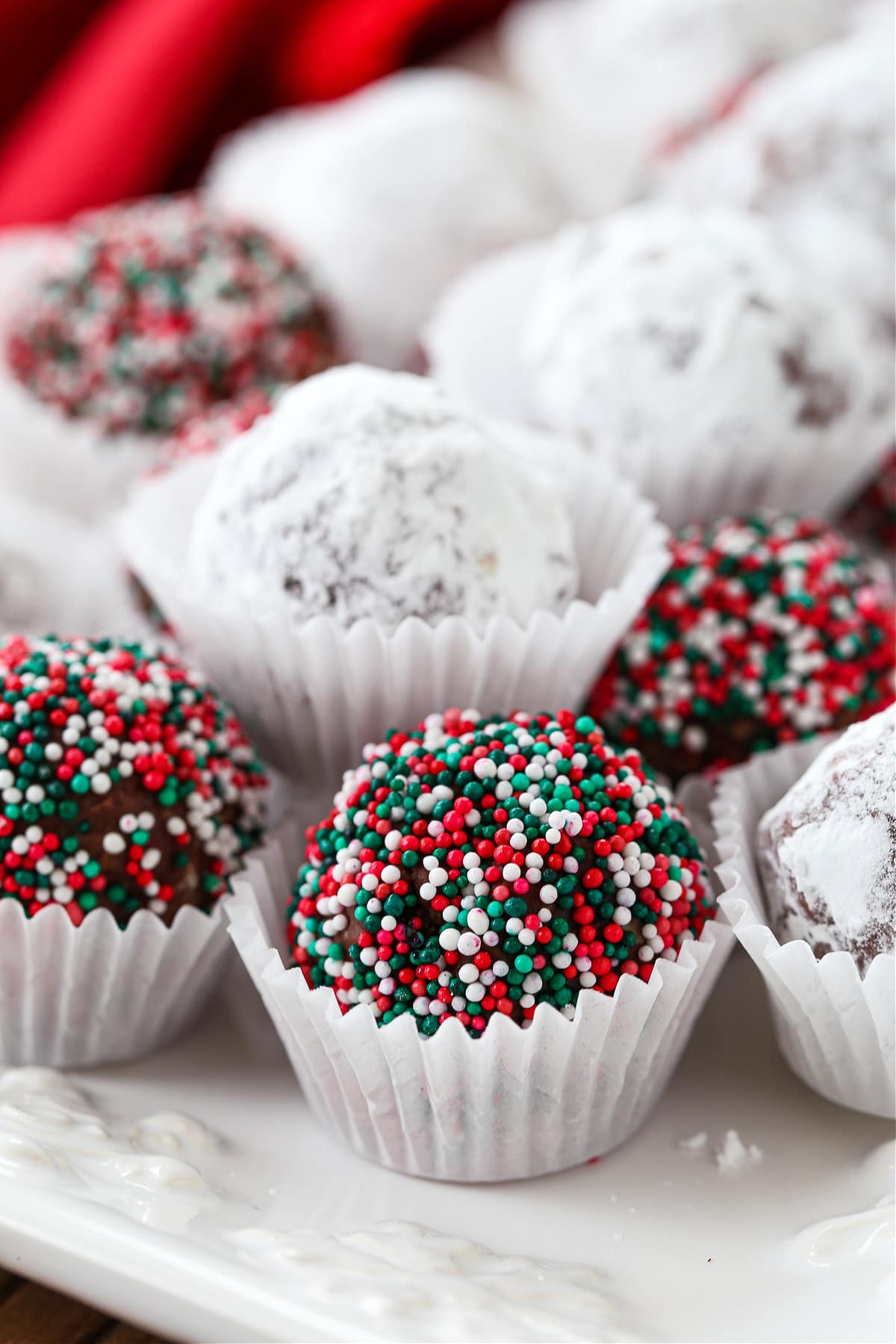 Rum Balls are a classic holiday dessert! This make ahead, festive treat can be customized for any occasion and pack a big punch of rum! rum balls decorated on platter