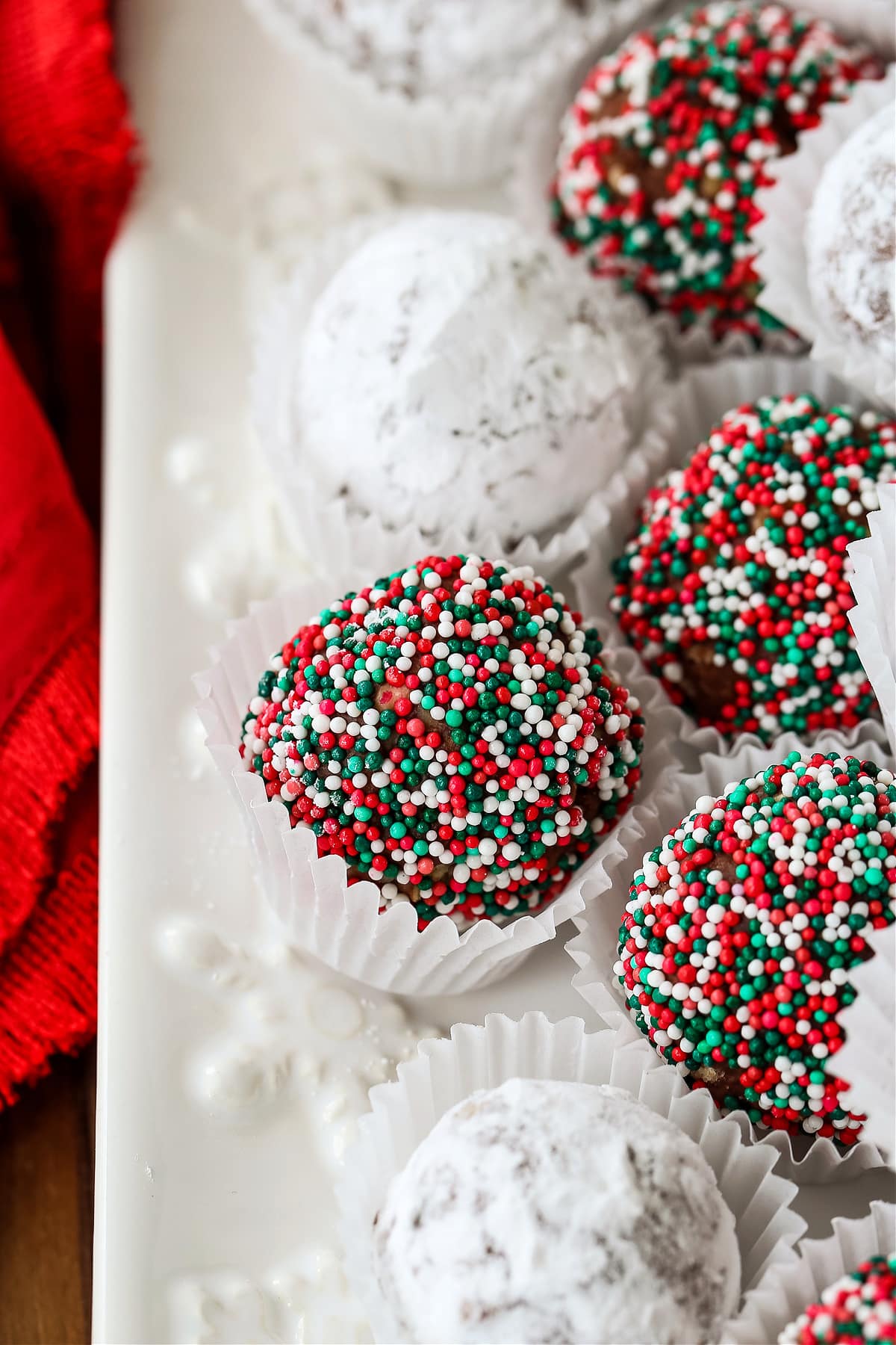 rum balls with sprinkles and powdered sugar on platter