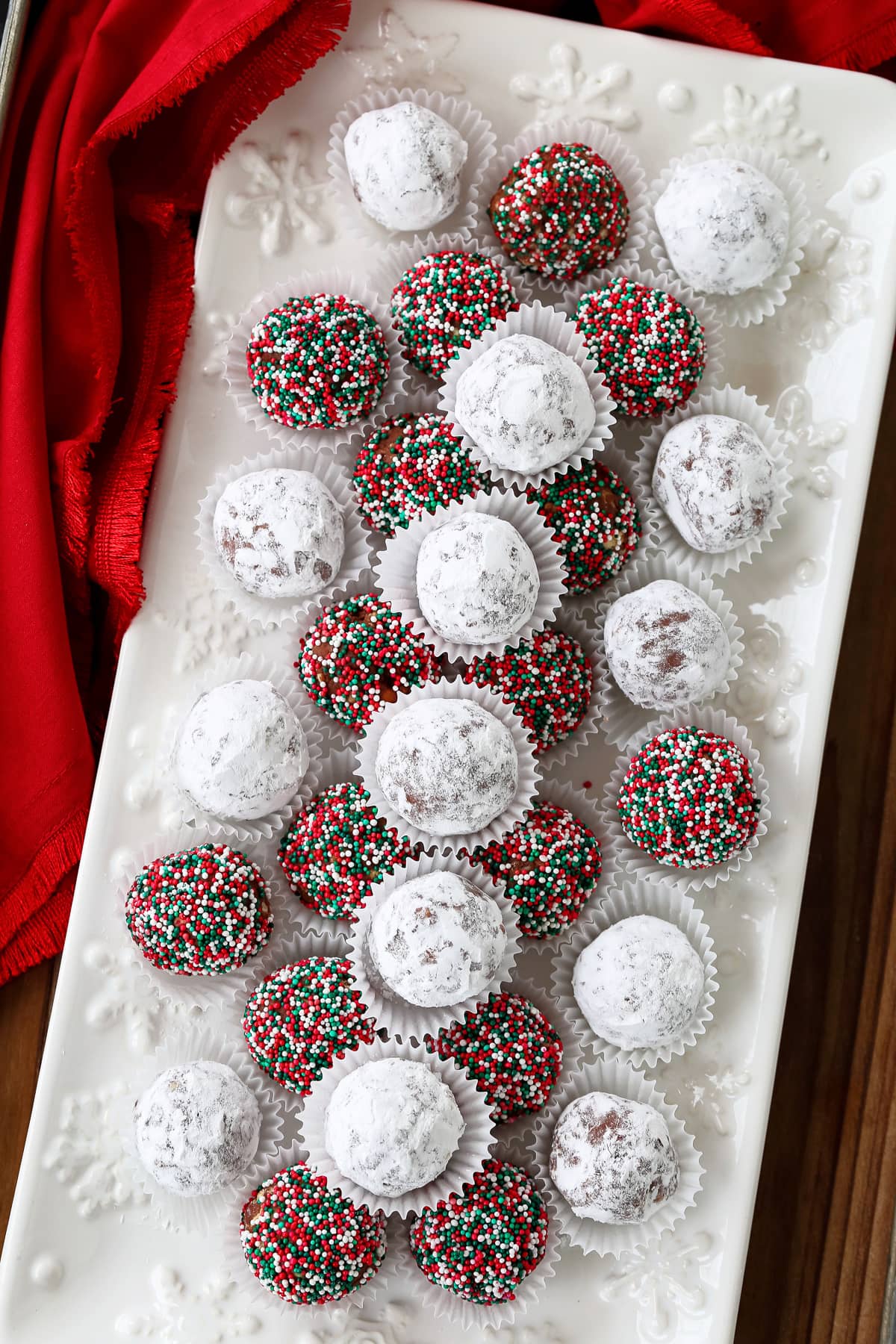 colored and sugared rum balls on a white platter