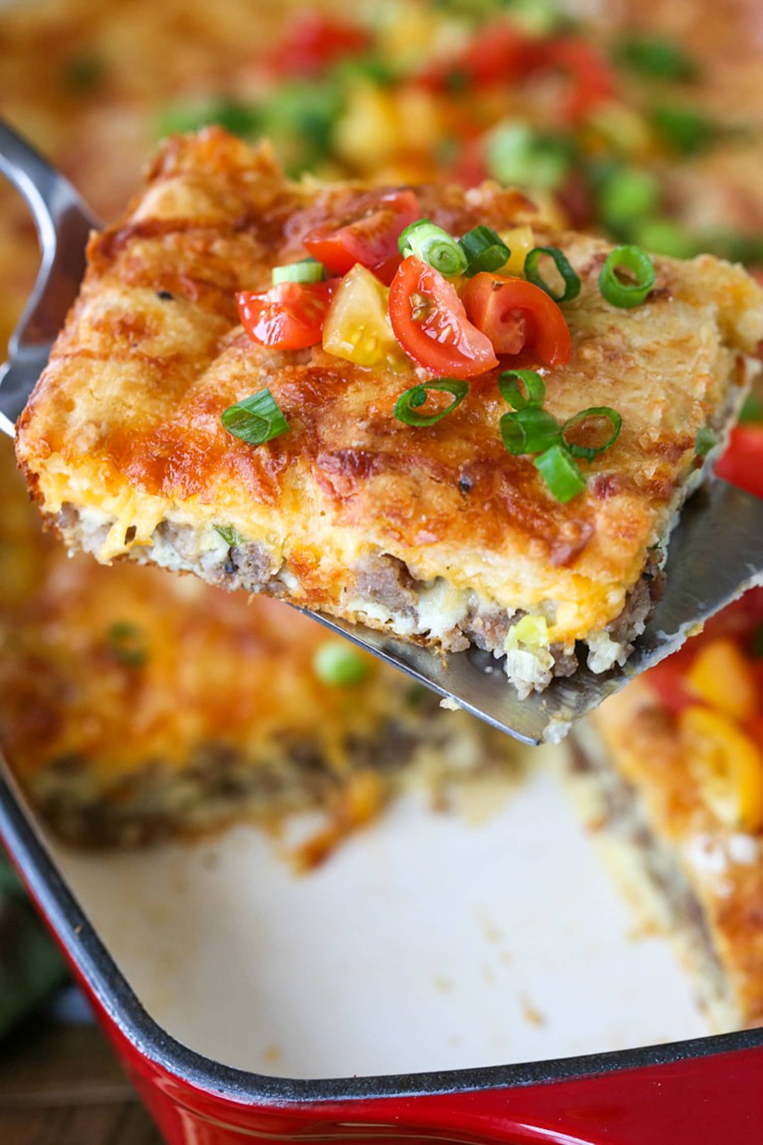 breakfast casserole with sausage and cheese topped with tomatoes