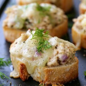 mini tuna melts on black platter with fresh dill