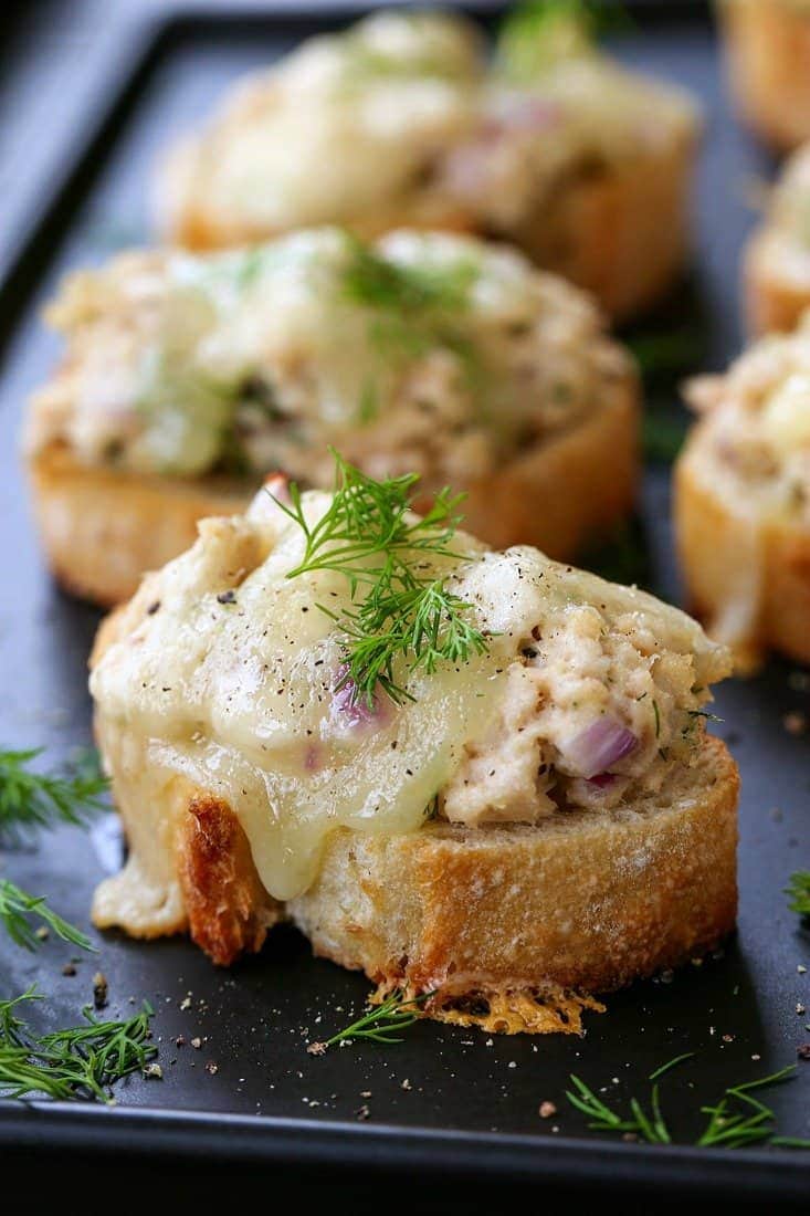 mini tuna melts on black platter with fresh dill