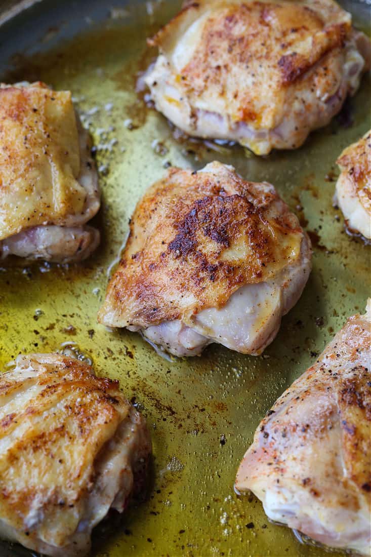 Chicken thighs browning in skillet