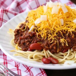 Cincinnati Chili served over spaghetti with beans, cheese and onions