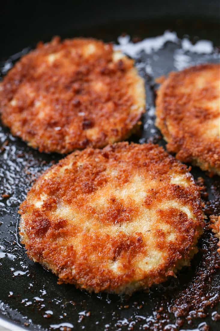 Crispy, fried slices of eggplant in the bottom of a pan.