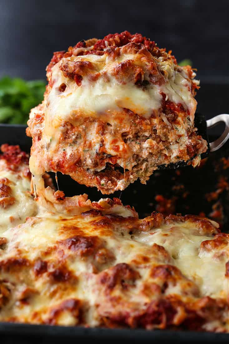 A slice of eggplant parmesan being lifted from the pan on a spatula.