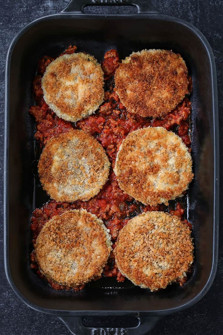 Fried eggplant and sauce in bottom of baking dish