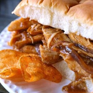 sweet pulled chicken on a roll with chips on the side