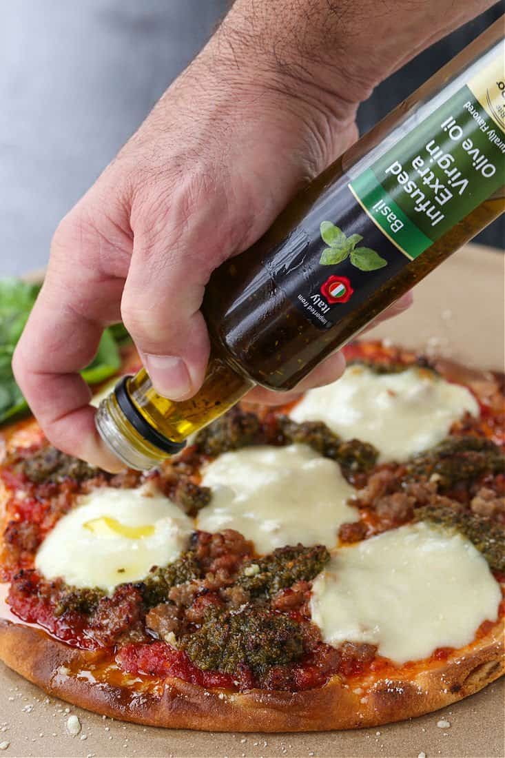 Basil olive oil drizzled onto a hot pizza