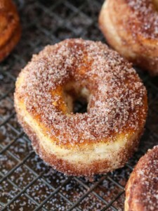 Cinnamon sugar donuts on baking rack to dry