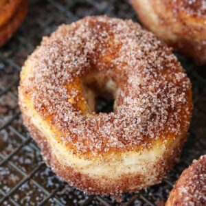 Cinnamon sugar donuts on baking rack to dry