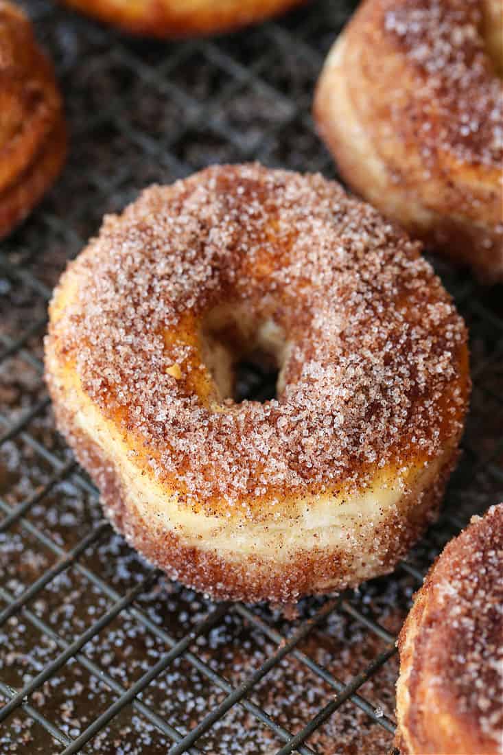 Cinnamon sugar donuts on baking rack to dry