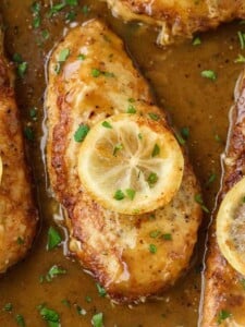 Chicken francese in a pan with a slice of lemon