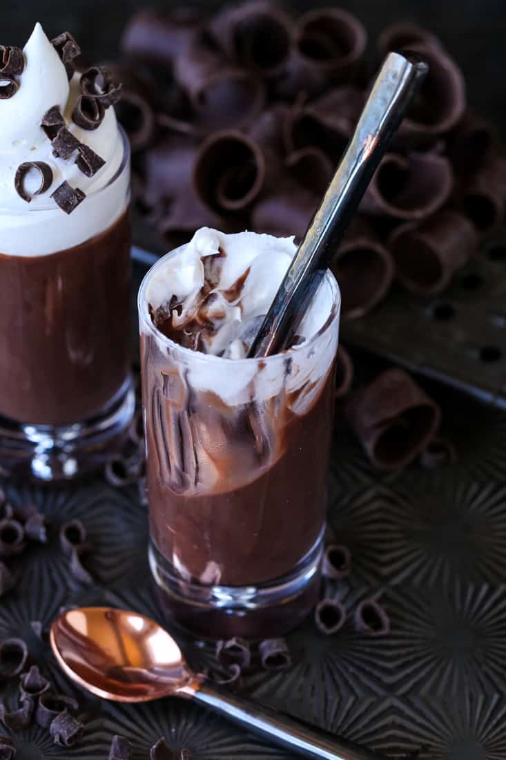 Chocolate Stout Pudding Shots for the beer lover in your life! A hint of flavor from chocolate stout, sweetened with a whipped cream topping! Chocolate pudding shots with a spoon in the glass