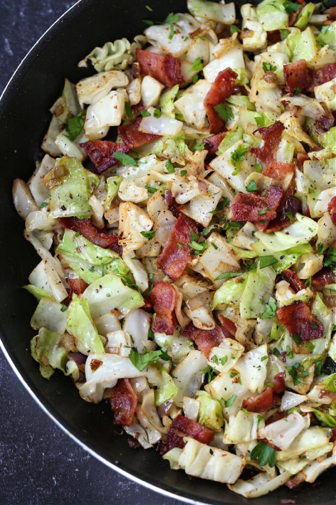 Fried Cabbage with Bacon is an easy side dish that goes with many meals! Sweet cabbage with crispy, salty bacon is the perfect combination! cabbage and bacon in a skillet