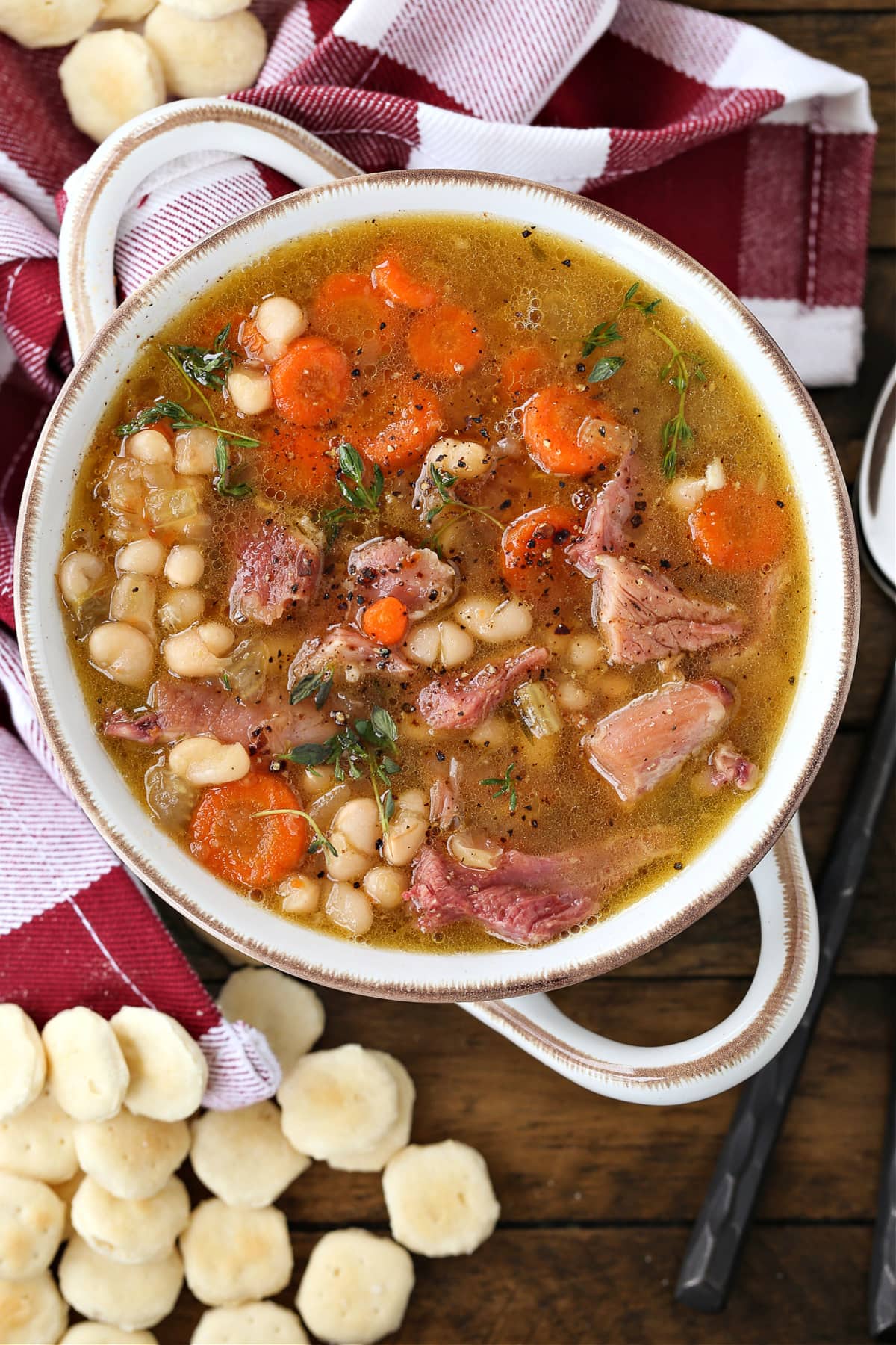 navy bean soup in a white crock with crackers on the side