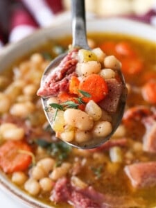 navy bean soup on a spoon over a bowl