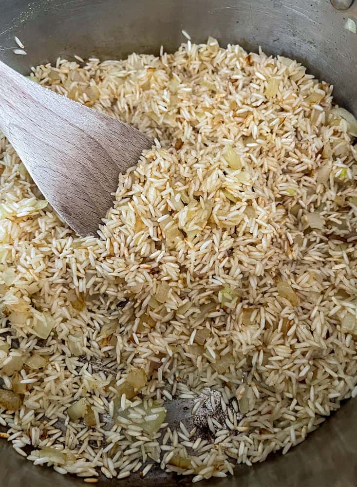 rice in a pot with a wooden spoon