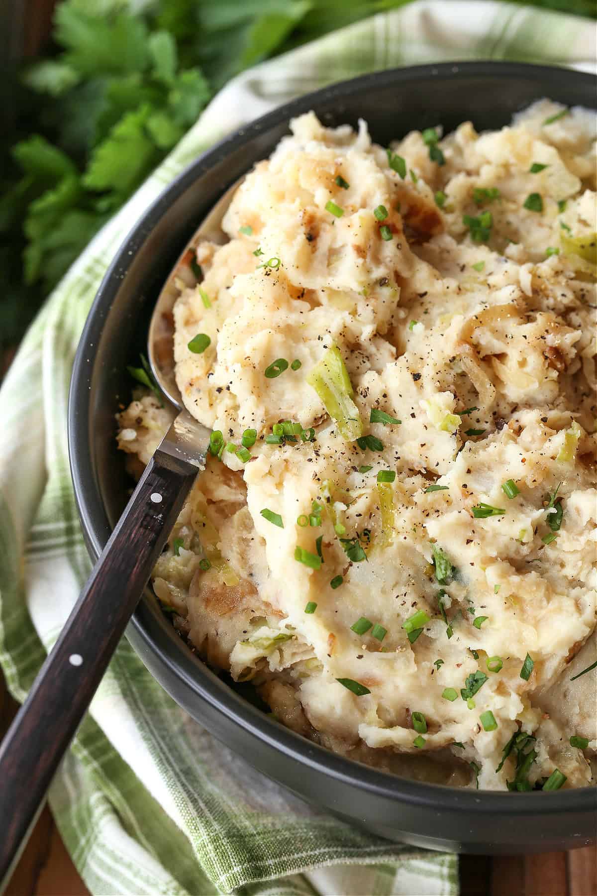Sweet bursts of caramelized onion and the slight crunch of steamed cabbage have made Colcannon a traditional Saint Patrick's Day favorite. The smooth and creamy mashed potatoes help the other flavors blend into a side dish that pairs perfectly with any meat. mashed potatoes with onions and cabbage in a bowl with spoon