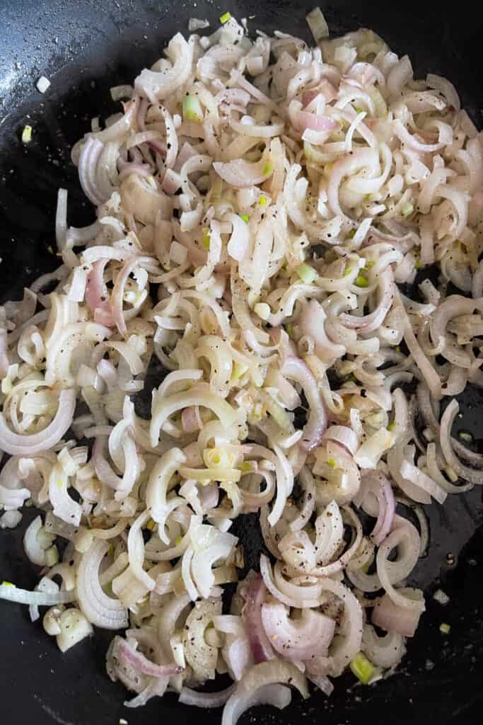 This Colcannon recipe is a St. Patrick's Day favorite! Creamy, buttery mashed potatoes blended with sweet caramelized onions and cabbage. sliced onions and cabbage in a skillet