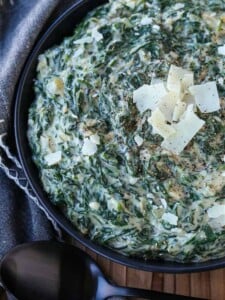 Creamed Spinach in a black bowl with parmesan cheese