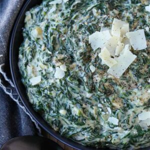 Creamed Spinach in a black bowl with parmesan cheese