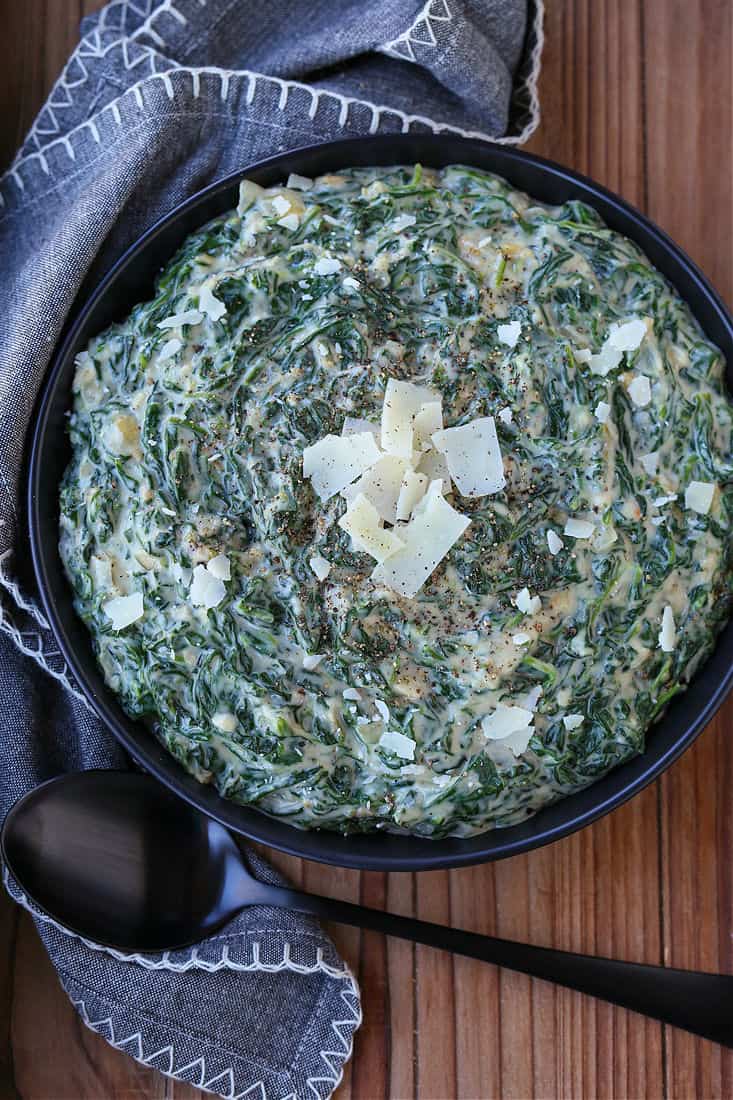 Creamed Spinach in a black bowl with napkin